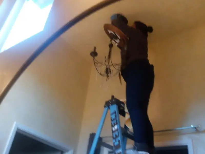 Electrician installing a chandelier in a Eureka residence